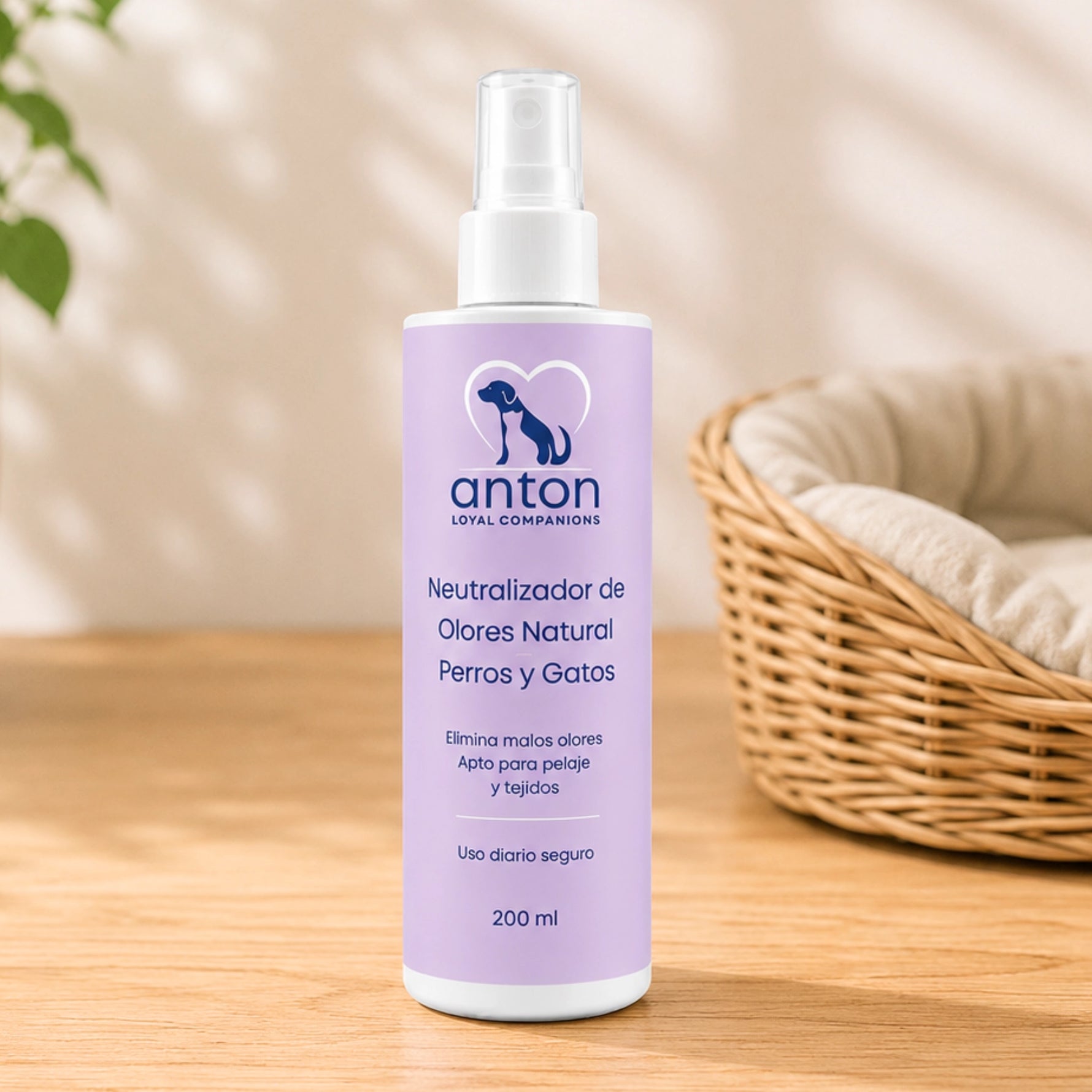 Botella de 200 ml del Neutralizador de Olores Natural ANTON Loyal Companions para perros y gatos, presentada sobre una superficie de madera con luz natural y una cama de mimbre al fondo. Fórmula apta para pelaje y tejidos, de uso diario.