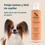 Acondicionador natural con aclarado Suavidad ANTON Loyal Companions para perros, 250 ml. Facilita el cepillado, deja el pelaje suave y brillante y es apto para uso frecuente, ilustrado junto a un perro de pelo largo.