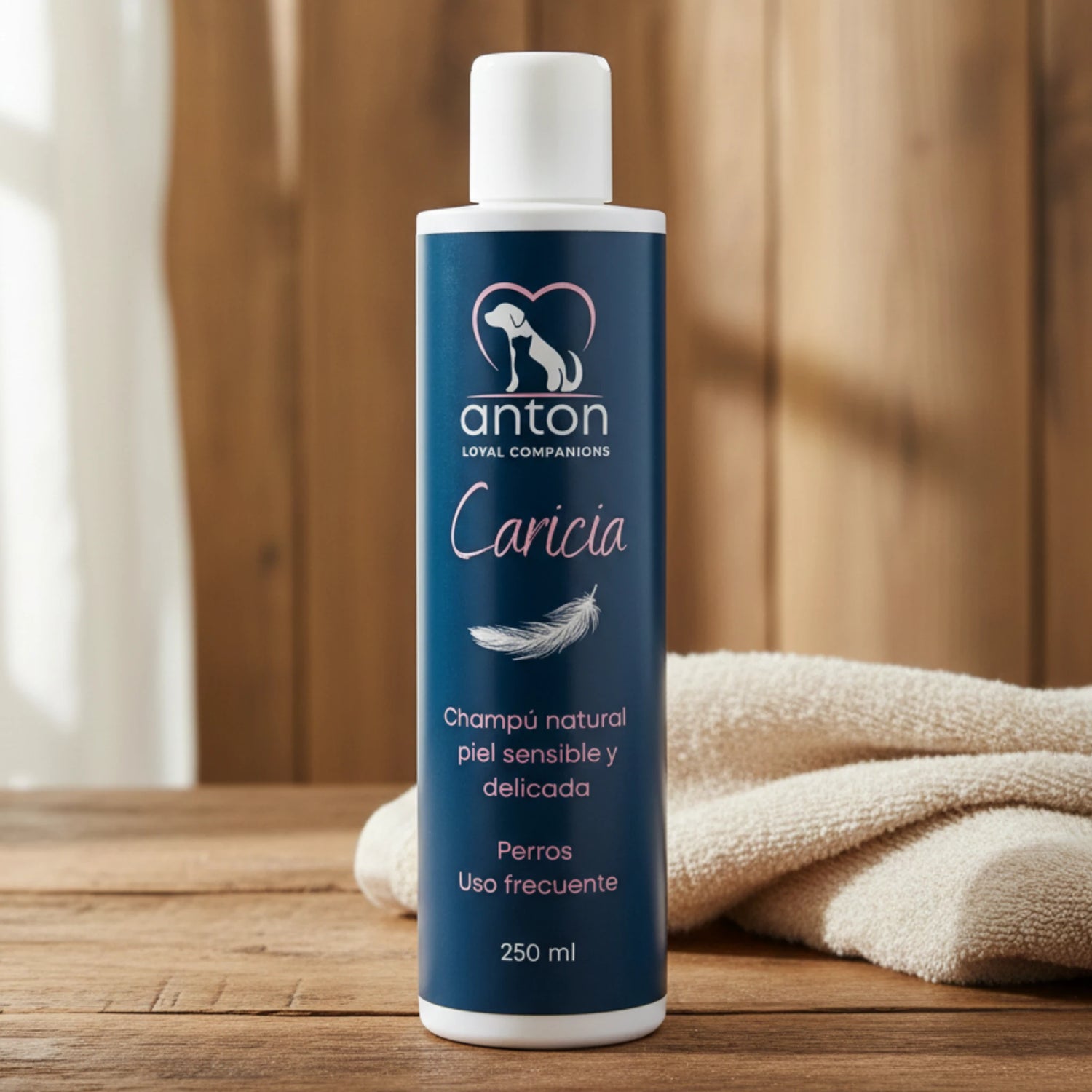 Champú natural Caricia ANTON Loyal Companions para perros, piel sensible y delicada, uso frecuente, frasco de 250 ml sobre mesa de madera con toalla beige suave