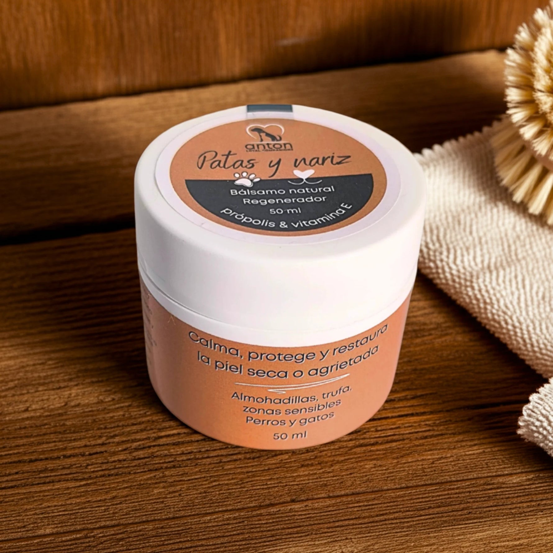 Bálsamo natural para patas y nariz de perros y gatos ANTON Loyal Companions sobre mesa de madera, calma y protege la piel seca y agrietada de forma natural.