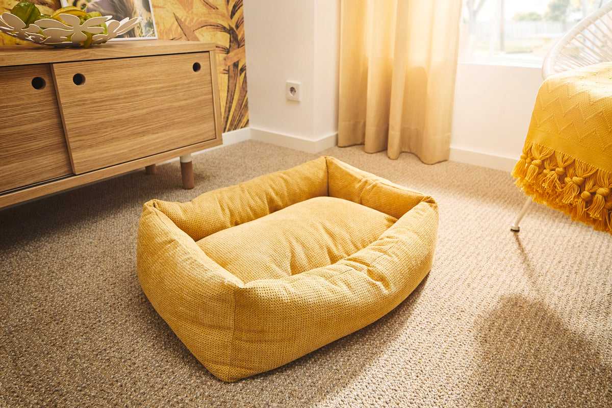 Cama para perros TUDOR color dorado en el interior de un hogar