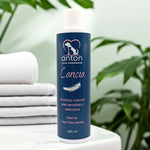 Champú natural Caricia para perros ANTON Loyal Companions sobre toallas blancas, ideal para piel sensible y delicada, uso frecuente, fórmula suave y natural.