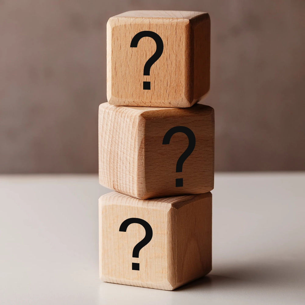 Bloques de madera con signos de interrogación que ilustran una sección de preguntas frecuentes sobre suplementos y productos para perros y gatos