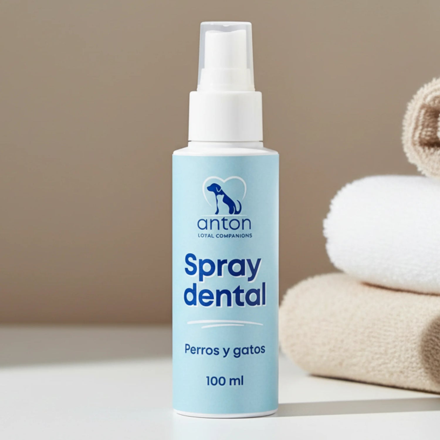 Spray dental natural para perros y gatos de ANTON Loyal Companions, frasco de 100 ml sobre superficie blanca con toallas en el fondo.